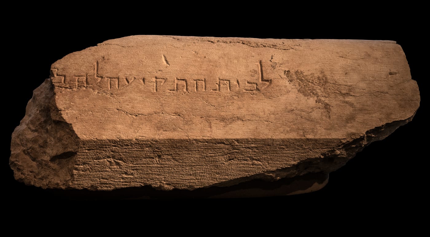 Sillar con la inscripción hebrea «לבית התקיעה» ('al lugar de la trompeta', seguida de una tercera palabra incompleta), hallado en 1968 por Benjamin Mazar al pie del ángulo suroeste del Monte del Templo, caído desde lo alto del muro. Señalaba el punto donde un sacerdote se situaba para tocar el shofar anunciando el comienzo y el final del sábado, un rito que Josefo describe en 'La guerra de los judíos'. No es un objeto 'saduceo' —de esa corriente no se conserva nada propio—, pero materializa el mundo que la definía: el culto sacerdotal del Templo herodiano. La piedra fue arrojada abajo en la destrucción del año 70, el mismo suceso que borró a los saduceos como grupo identificable.