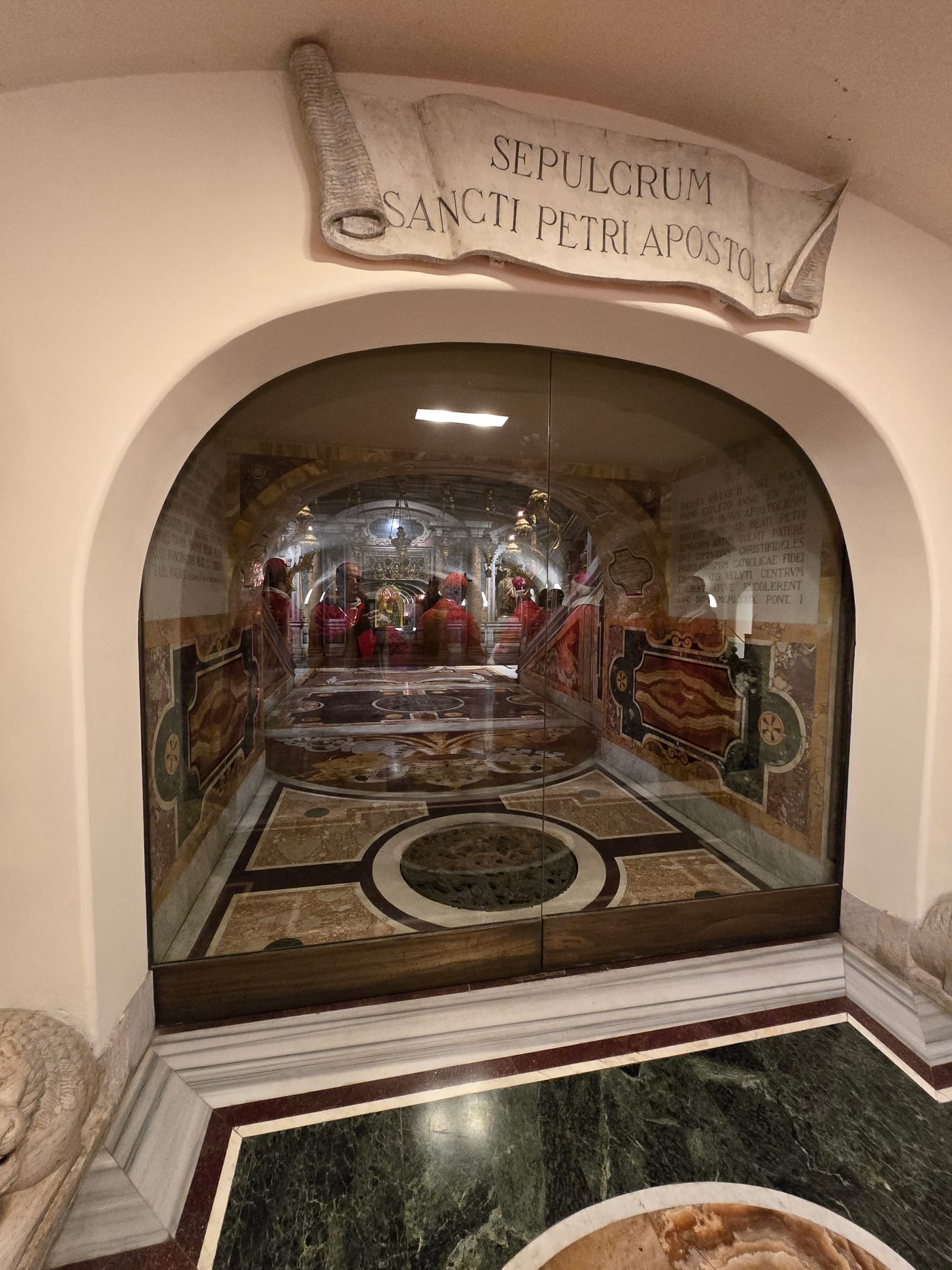'Sepulcrum Sancti Petri Apostoli' — acceso a la necrópolis vaticana bajo la Basílica de San Pedro, excavada entre 1940 y 1949, donde la tradición sitúa la tumba de Pedro. La identificación arqueológica de los restos con el apóstol es objeto de debate académico; lo que sí está confirmado es la antigüedad del culto en ese lugar preciso.